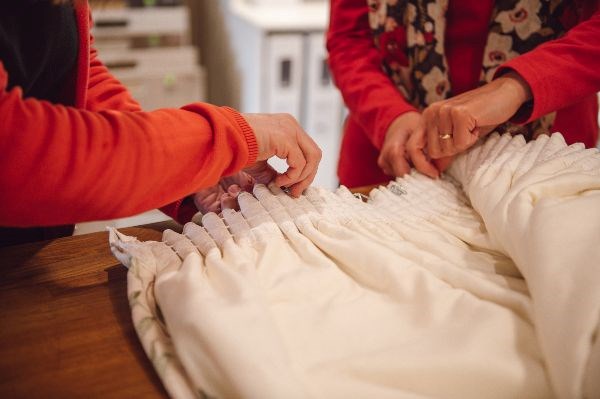 two people holding the top of a curtain